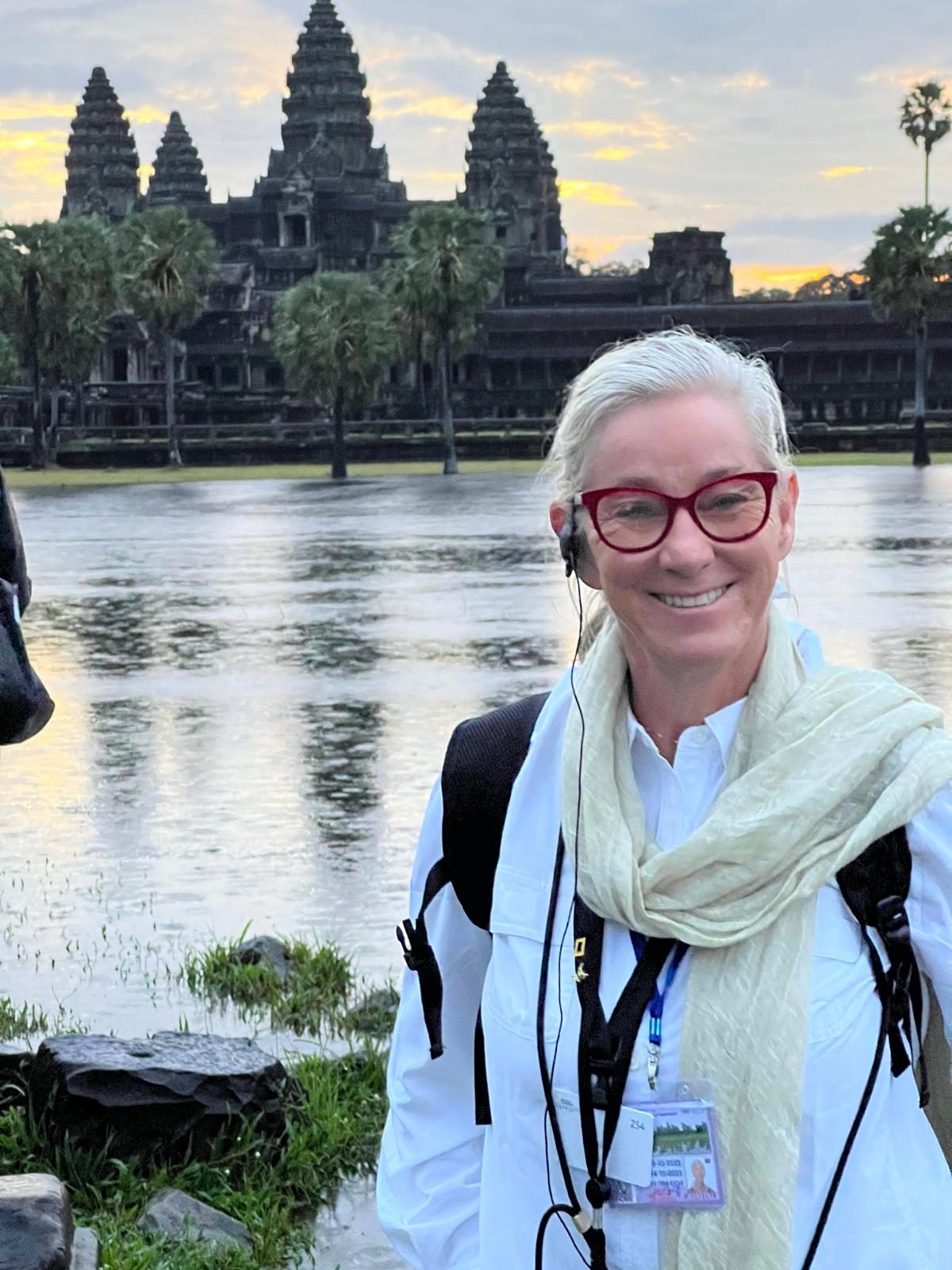 Susi smiling at sunrise beside the reflecting pool at Angkor Wat
