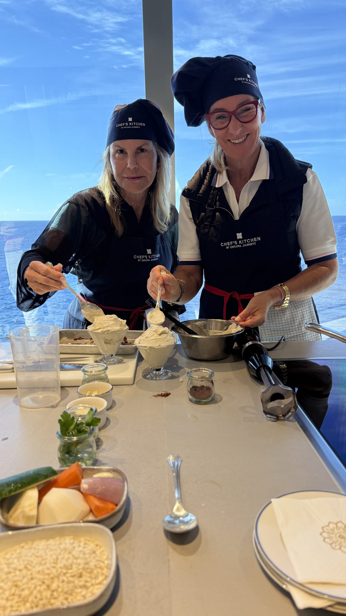 Susi in chef’s whites at a cooking class aboard ship, overlooking the sea