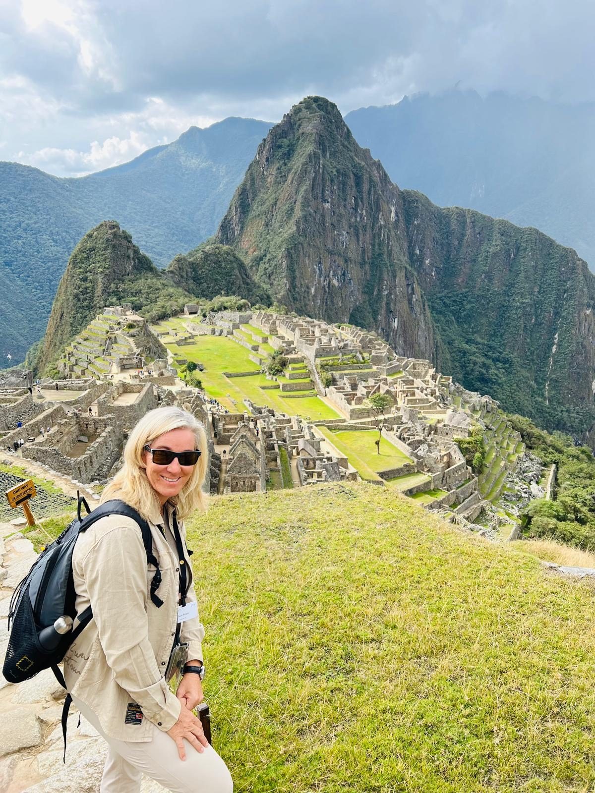 Susi above the terraces of Machu Picchu with Huayna Picchu rising behind