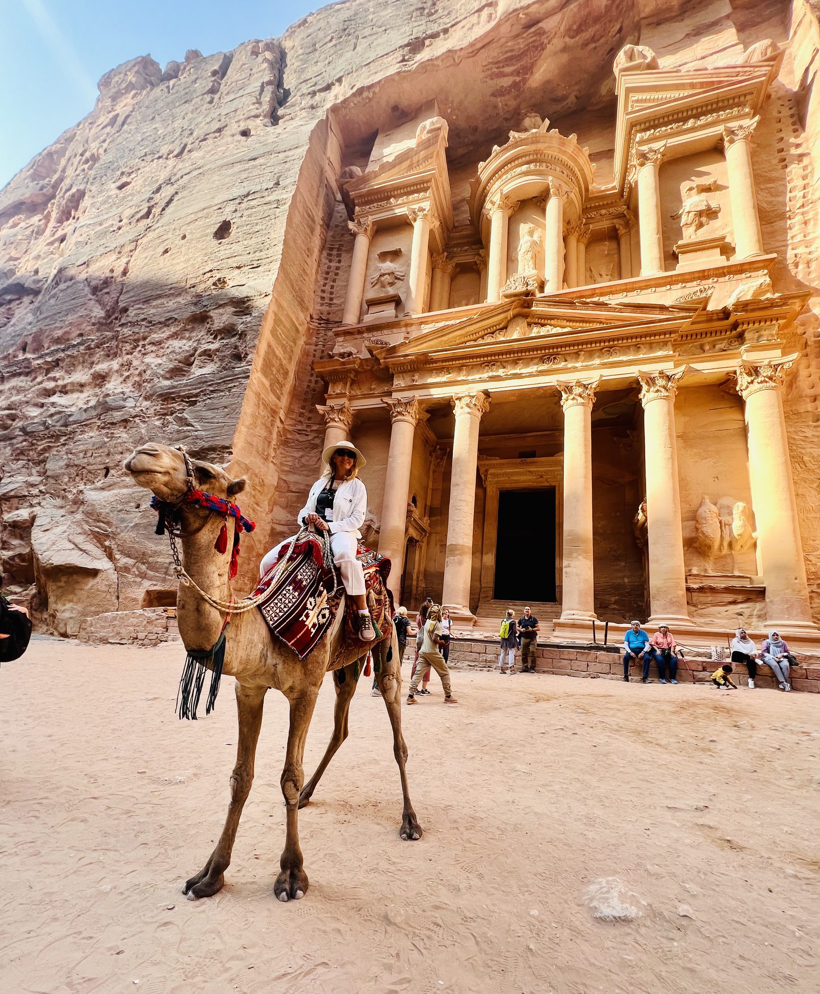 Susi riding a camel in front of the Treasury at Petra, Jordan