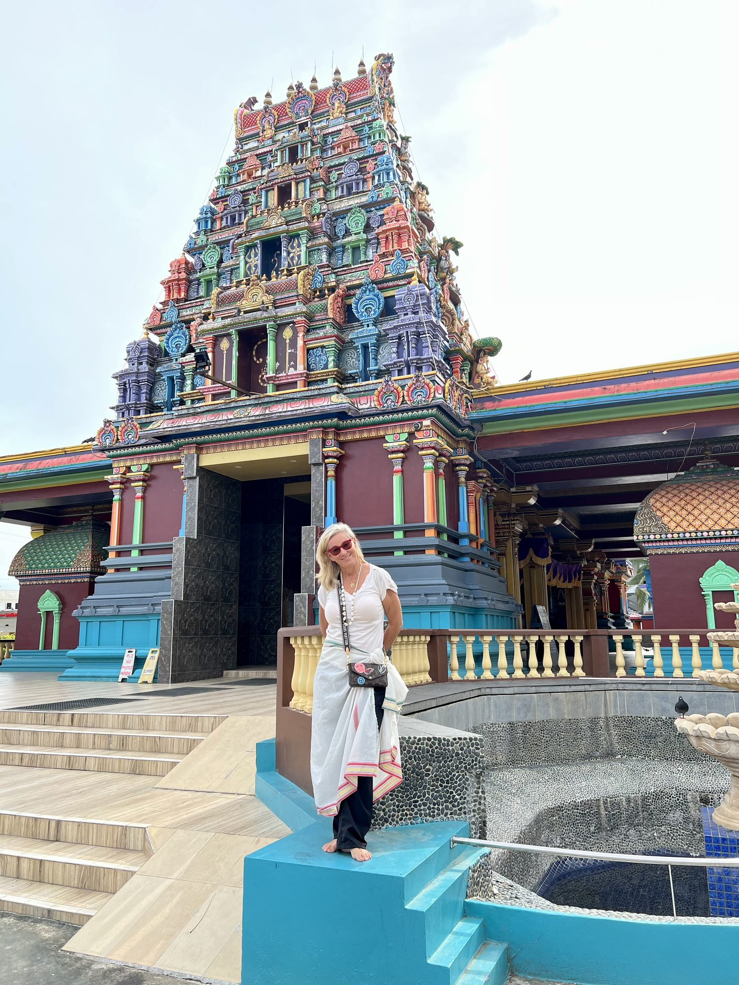 Susi standing before a brightly painted Hindu temple
